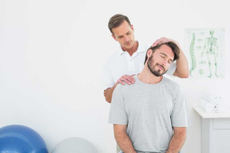 A person receiving gentle instrument-assisted therapy on the forearm using a stainless steel tool.